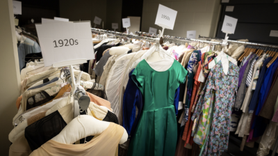 Racks of dresses labeled with different decades fill a room of the Oris Glisson Historical Costume and TextileCollection.